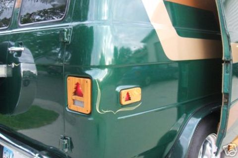 1978 Ford E250 - This van has a distinctive side panel with a tan stripe and decorative wooden accents around red tree emblems.