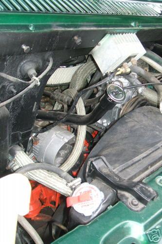 1978 Ford E250 - Close-up view of a green engine bay, showing various engine components and hoses.