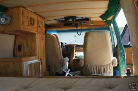 1978 Ford E250 - Interior view of a van with custom wood cabinetry and seating.