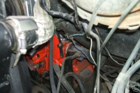 1978 Ford E250 - Close-up view of an engine bay, showing an orange engine block and various hoses and wires.