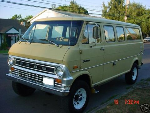 1978 Ford E250 - Front three-quarter driver's-side view of a tan/cream Ford Club Wagon van with chrome grille spelling 'FORD', round dual headlights, chrome…