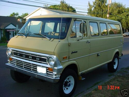 Tan Ford Club Wagon van front three-quarter view with chrome FORD grille and white spoke wheels