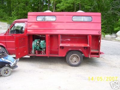 1978 Ford E250 - A red truck with a custom-built camper body is parked outdoors, with its side compartments open to reveal a generator.