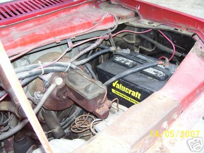 1978 Ford E250 - Close-up view of a vehicle's engine bay, showing the battery and brake fluid reservoir.