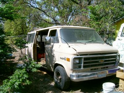 1978 Ford E250 - This 1977 Chevrolet van is parked outside with its driver's door ajar.