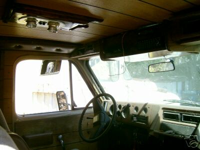 1978 Ford E250 - The interior of a van shows a wood-paneled ceiling, dashboard, and steering wheel.