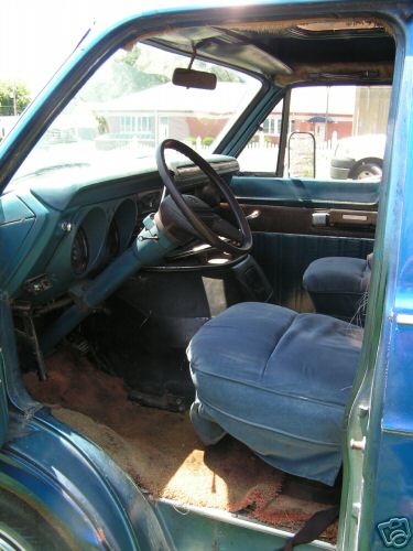 1978 Ford E250 - The interior of a blue 1978 Ford E250 van, the dashboard, steering wheel, and front seats.