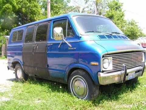 1978 Ford E250 - This blue van, likely a 1977 model, is seen from a three-quarter front angle in a grassy area.