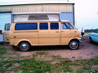 1978 Ford E250 - A vintage Ford Econoline camper van is parked outside a building, with another vehicle visible to the right.