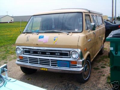 1978 Ford E250 - This 1978 Ford E250 van features a prominent "FORD" grille and American flag and ribbon decals on its hood.