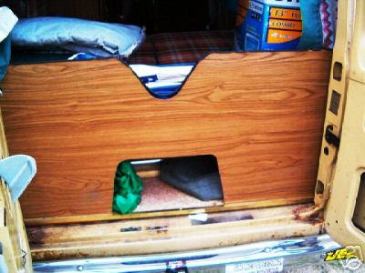 1978 Ford E250 - Wood paneling and storage visible in the rear interior of a van.