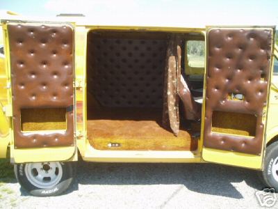 1978 Ford E250 - Rear and side doors of a yellow full-size Ford van standing open, revealing a custom interior with brown tufted button upholstery panels an…