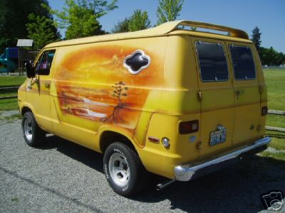 1978 Ford E250 - A vintage full-size cargo van shown in rear three-quarter view, painted in a custom yellow-to-orange sunset airbrush mural with a porthole-…