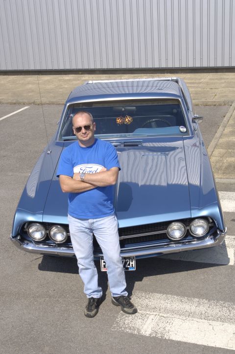 1970 Ford Ranchero - A man poses in front of a blue 1970 Ford Ranchero, showing off the vehicle's front end.