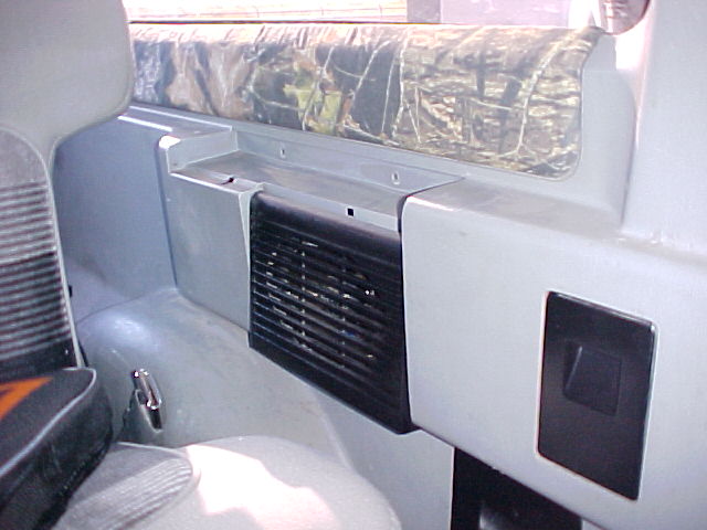 Interior panel with black vent and camouflage upholstery above. A silver latch is visible on the left