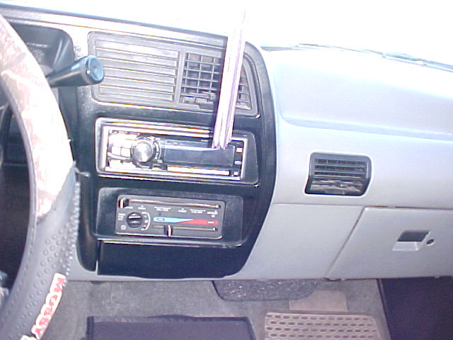 Dashboard with radio, climate controls, and air vents. Steering wheel visible on left