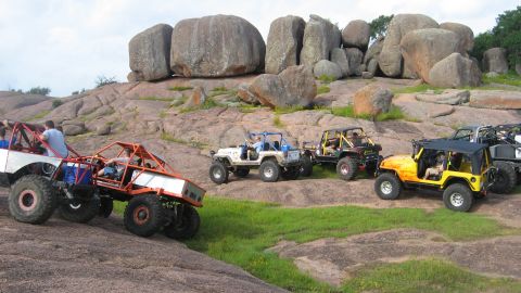 1979 Ford Bronco - Multiple off-road vehicles navigate a challenging rocky landscape.
