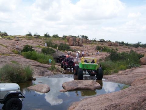 1979 Ford Bronco - Off-road vehicles traverse a challenging rocky landscape with water features.