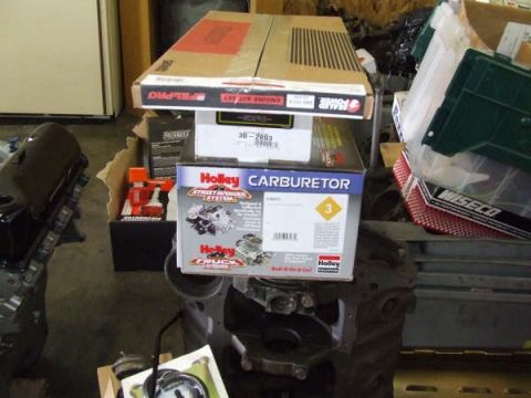1979 Ford Bronco - Various engine parts are organized in boxes, including a Holley carburetor and a Pel-Pro engine kit.