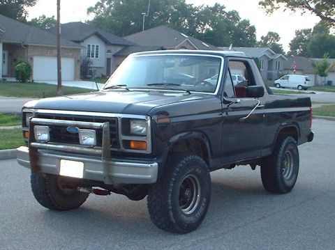 1985 Ford Bronco - driver front, nice dent, lost to a garbage dumpster's fence.