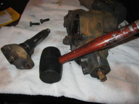 1991 Ford Bronco - A hydroboost part is shown with a rubber mallet and bolts on a towel, suggesting a repair or maintenance activity.