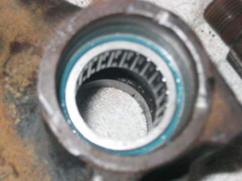 1991 Ford Bronco - Close-up view of a bearing assembly with a blue seal and roller elements.