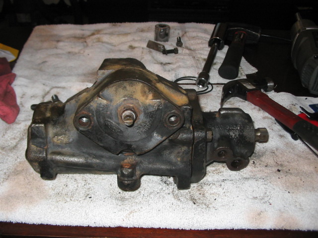 Used power steering gearbox on a white towel with tools