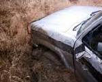 1990 Ford Ranger - A silver pickup truck is seen from a 3q-front angle, partially obscured by dry grass and vegetation, suggesting it may be off-road or aband…