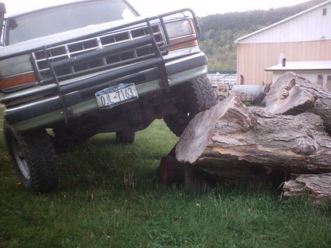 1990 Ford Ranger - A 1990 Ford Ranger navigates over a large log in a grassy area.