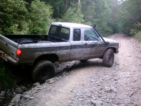 1990 Ford Ranger - This Ford Ranger pickup truck is equipped with a snorkel and appears to be navigating a challenging off-road terrain.