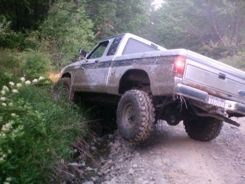 1990 Ford Ranger - This 1990 Ford Ranger is navigating a challenging, muddy, and rocky off-road path.