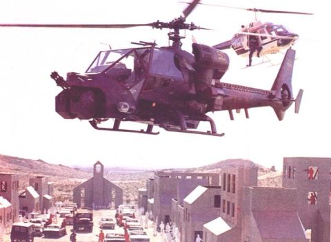 2007 Nissan Titan - A military-style helicopter and a police helicopter fly over a staged town scene with cars and people.