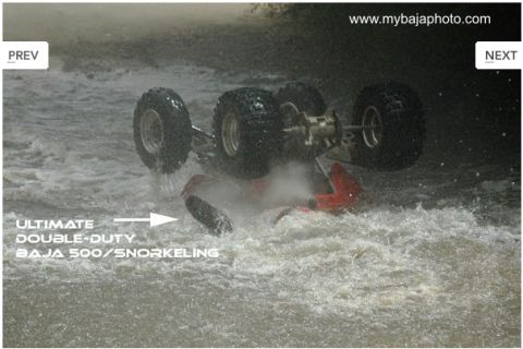 1992 Ford Explorer - An ATV is submerged and overturned in rushing water, with text indicating it's a Baja 500 model.