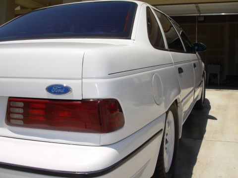 1995 Ford Taurus - Rear view of a white 1995 Ford Taurus sedan parked in a garage.