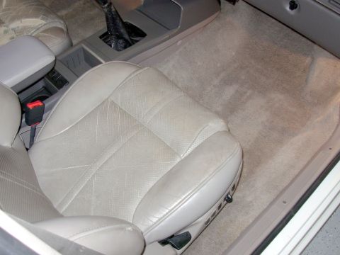 1995 Ford Taurus - Interior view showing the driver's seat, center console, and floor carpeting.