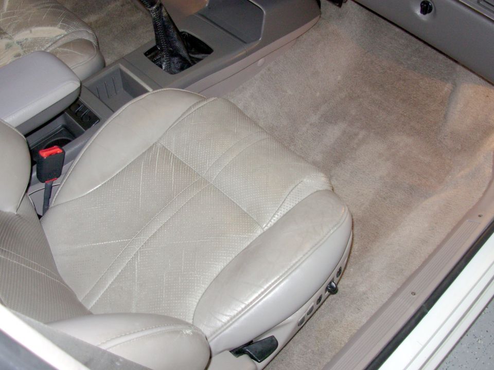 Interior view of light-colored leather seats and center console