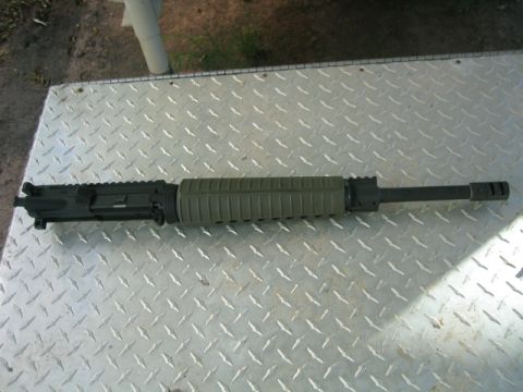 1973 Ford F-100 - An AR-15 upper receiver and barrel assembly is displayed on a metal surface.