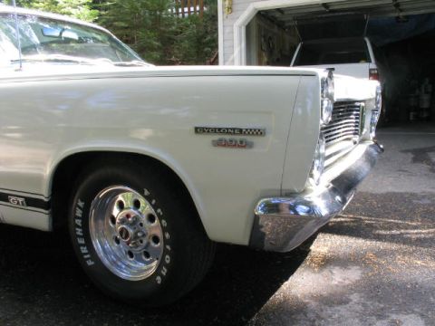 1973 Ford Ranchero - A white Ford Cyclone 390 is parked in front of a garage, with another vehicle visible inside.