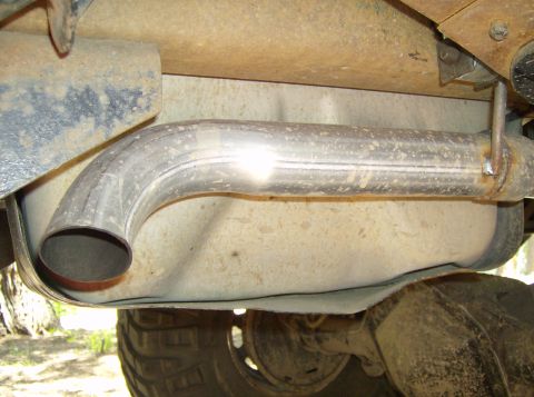1986 Ford Bronco - Exhaust pipe and fuel tank are visible from underneath the vehicle.