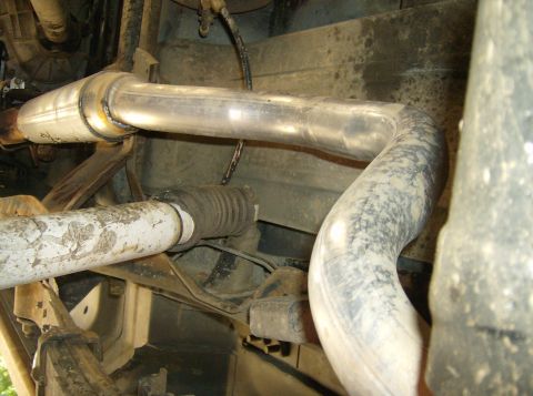 1986 Ford Bronco - Close-up of the exhaust system components, showing pipes and a muffler.