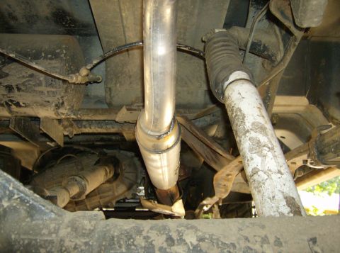 1986 Ford Bronco - Close-up view of the undercarriage, focusing on the exhaust system and suspension parts.