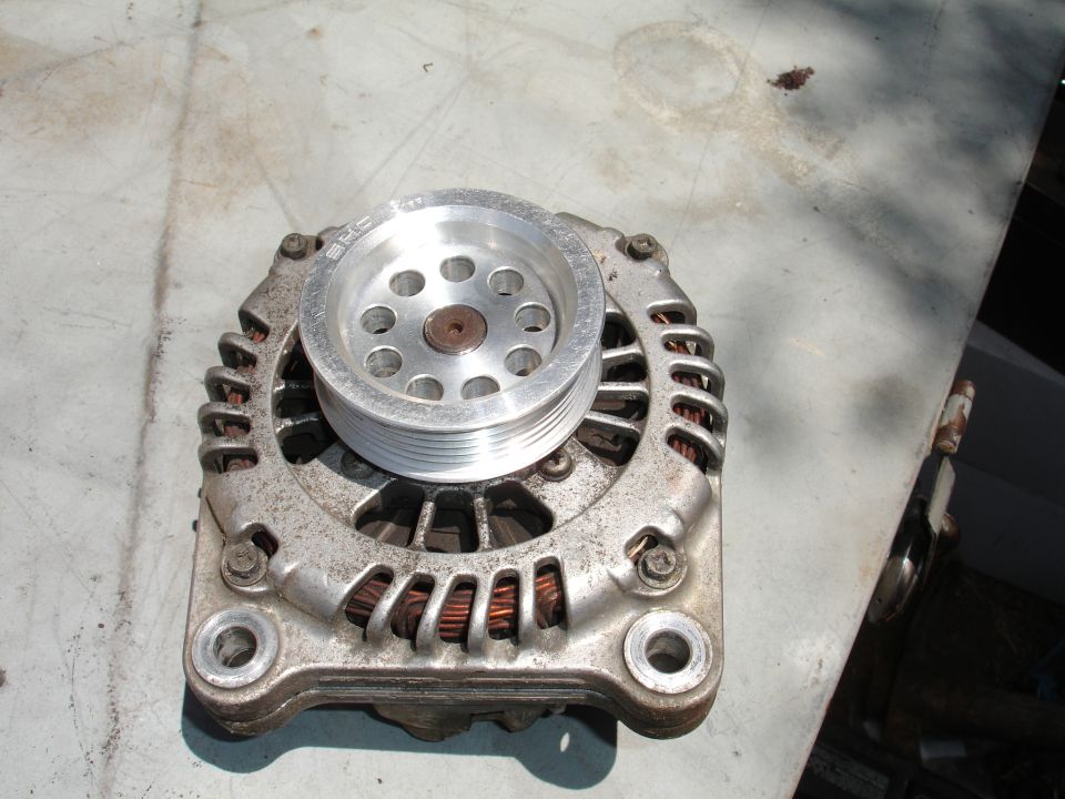 Car alternator with a shiny pulley. Text on pulley reads 'SHG'