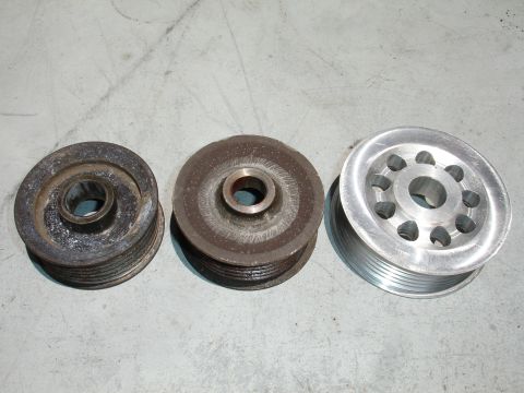 1993 Ford Taurus - Comparison of three automotive pulleys, showing varying states of wear and material.