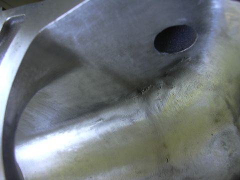 1996 Ford Crown Victoria - A close-up view of a metal component, possibly an intake plenum, showing internal casting details and a circular opening.