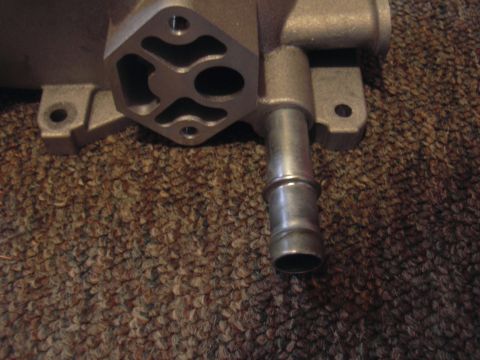 1996 Ford Crown Victoria - Metal automotive part with a hose barb is shown against a carpeted background.