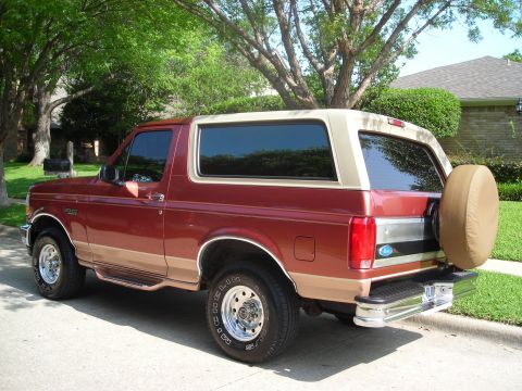 1995 Ford Bronco - This 1995 Ford Bronco is shown in a rear three-quarter view, highlighting its two-tone paint scheme and exterior spare tire.