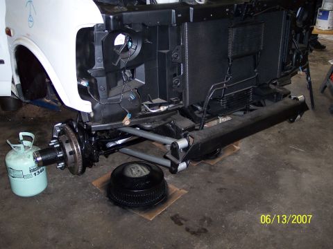 1996 Ford Bronco - The front end of a white van is disassembled, revealing the radiator and suspension parts.