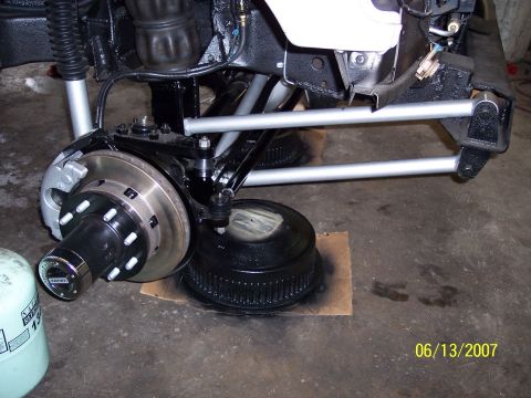 1996 Ford Bronco - Close-up view of a vehicle's front suspension and brake system, showing the rotor and hub assembly.