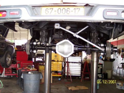1996 Ford Bronco - Underside view of a vehicle's rear axle and suspension system, air bags and a license plate.