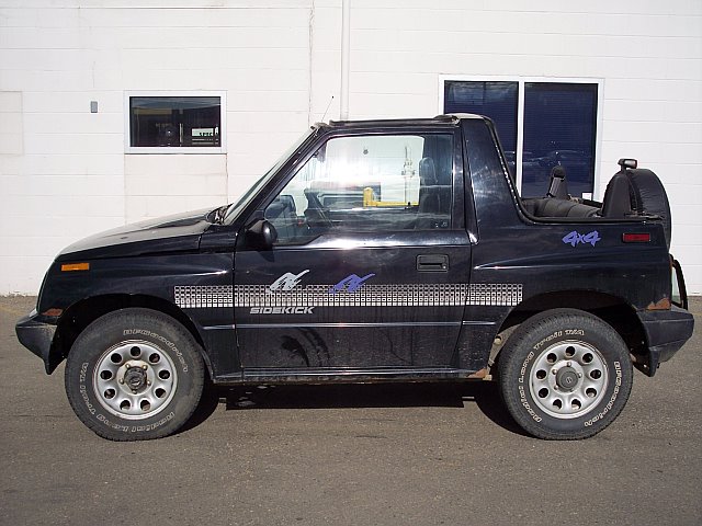 Black 2-door SUV with 'Sidekick' and '4x4' decals